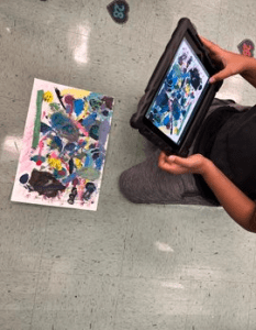 Student uses iPad to take a picture of and publish his art work.